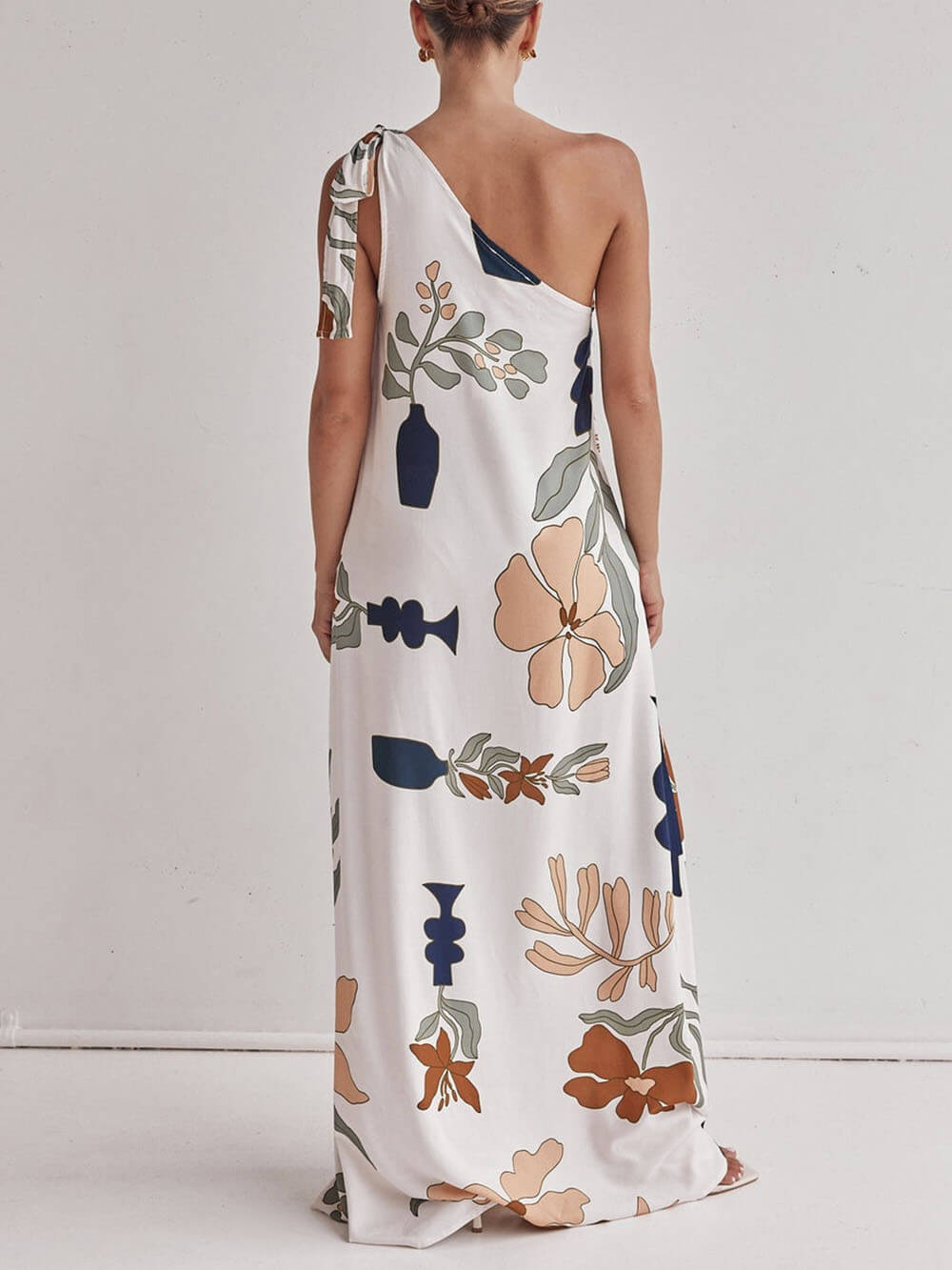 Asymmetrisk blommig klänning med elegant axelband