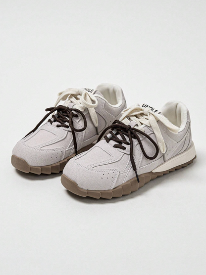 Produktfoto av en beige sportig sneaker med tvåfärgad spets.