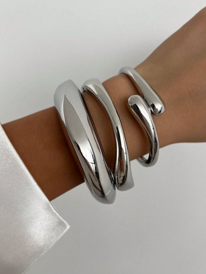 Modellen bär tredelat chunky armband i silver.